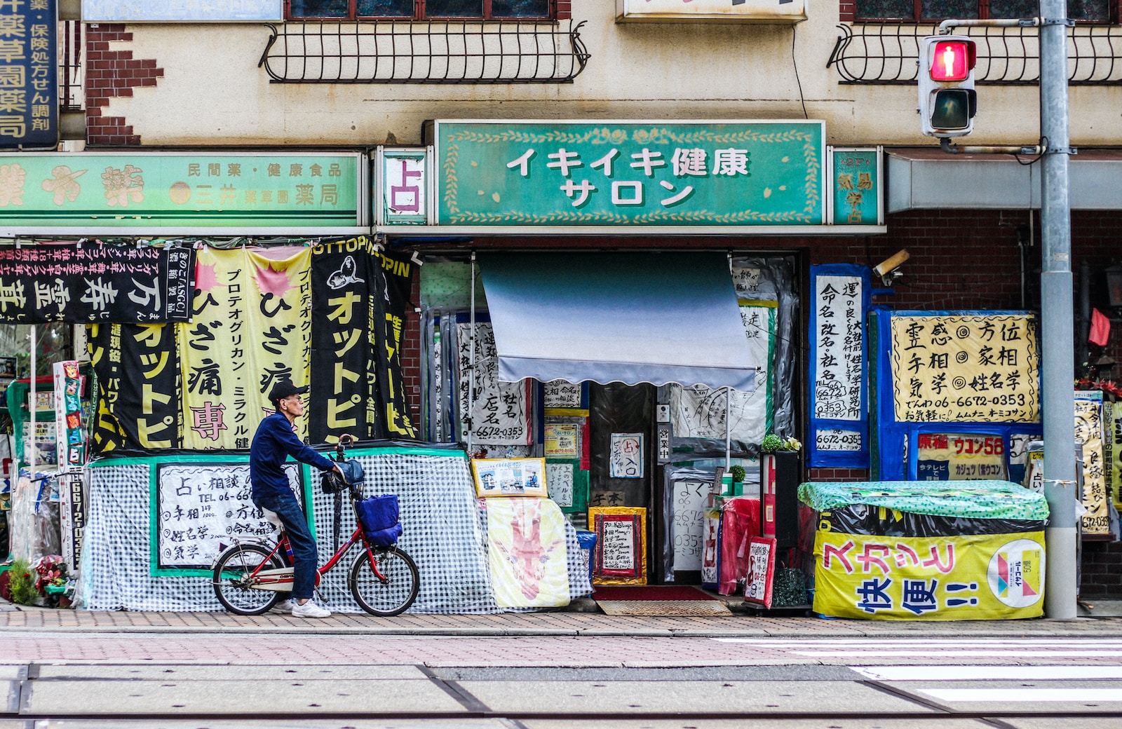 man riding red folding bike parked beside blue and white store