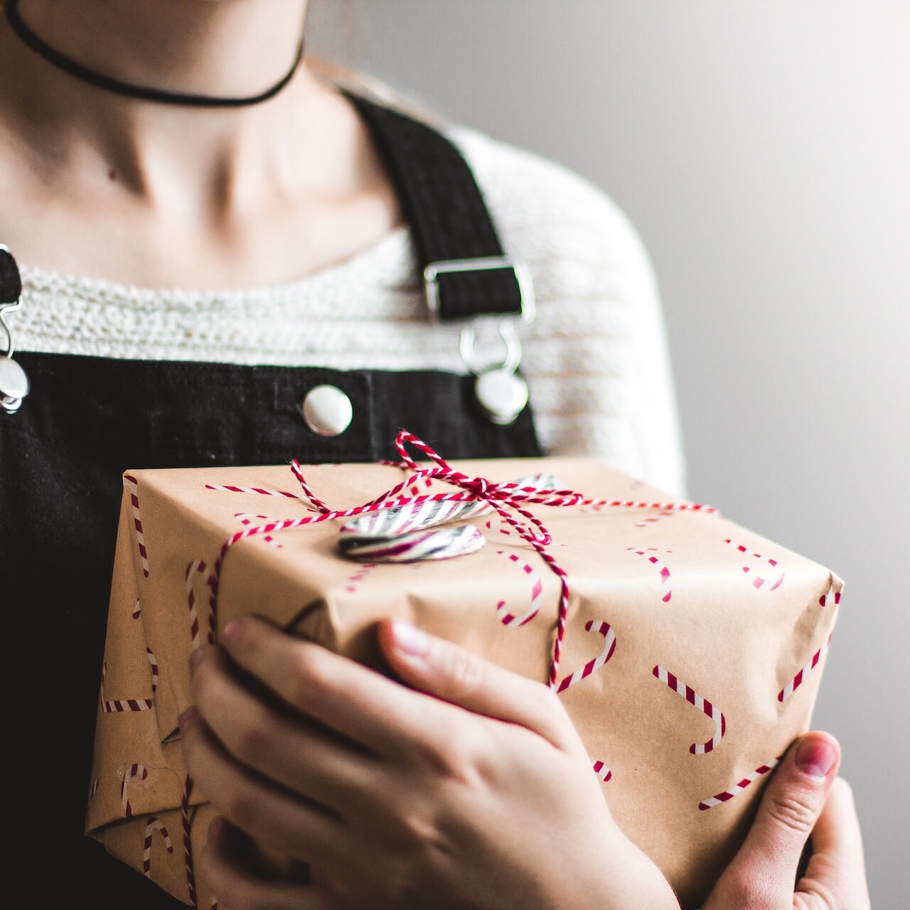 close up photography of woman holding grey and red box